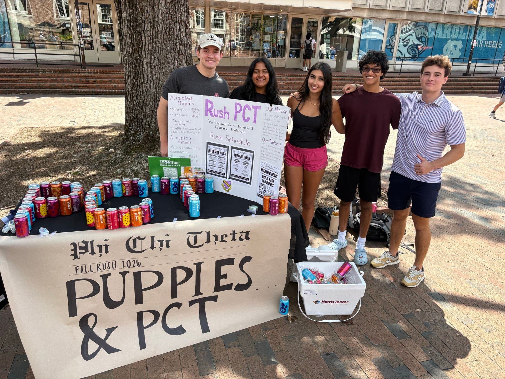 Members standing behind the Puppies & PCT table and banner